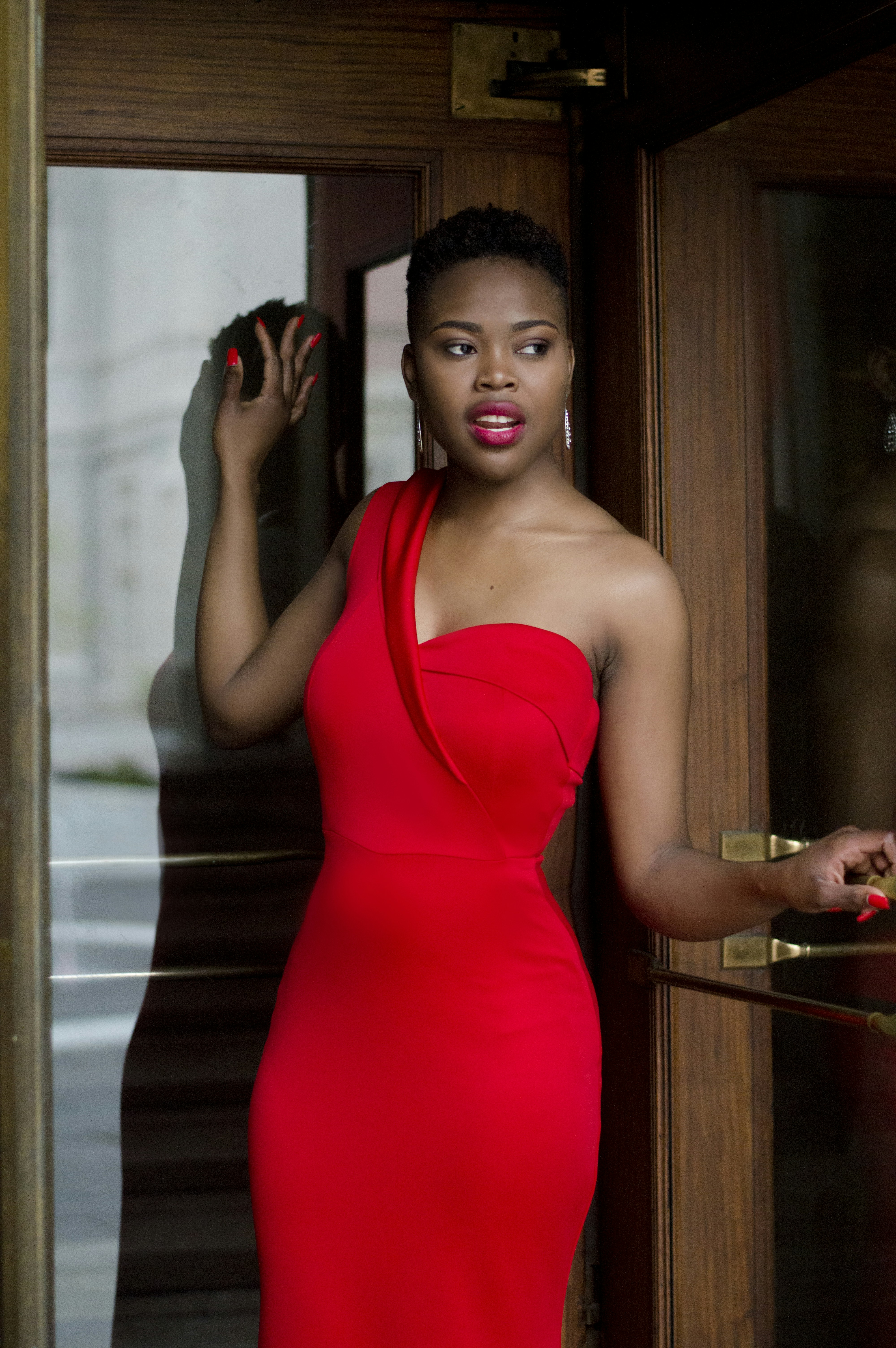 woman wearing red bodycon dress holding ...